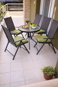 a patio with a table and chairs on a balcony at Epanomi apartment in Epanomi