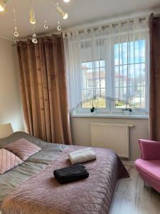 a bedroom with a bed and a window at Apartament Lake Piastowska in Ostróda