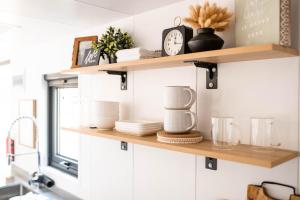 a kitchen shelf with dishes and a clock on it at Gold Mine Lofts in Idaho City