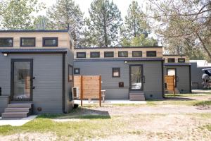 a tiny house with a garage in a yard at Gold Mine Lofts in Idaho City