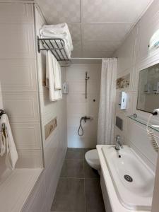 a white bathroom with a sink and a toilet at Üzüm İskelesi in Ahmetçe