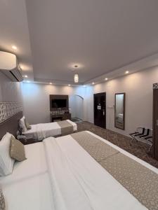 a large bedroom with a large bed and a living room at فندق الميار , Al Mayar Hotel in Medina +28 photos