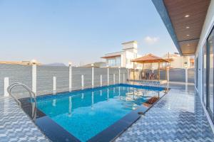 a swimming pool with a gazebo on a building at Jalsa Bungalow in Malavli