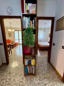 a living room with a book shelf filled with books at Casa Aurea Lake Como Apartment in Esino Lario