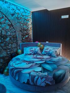 a bedroom with a blue bed with a stone wall at Suite San Giovanni in Gela +28 photos