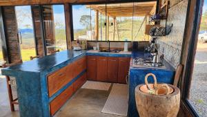 a kitchen with a blue counter top and a stove at Cabana do Retiro Refúgio Rústico na Natureza! in Alto da Conceição