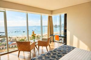 a bedroom with a bed and a view of the ocean at Hotel Terrado Cavancha in Iquique