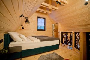 a bedroom with a bed in a wooden cabin at B&B Plitvice Holiday Lodge in Plitvička Jezera