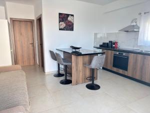 a kitchen with a table and some chairs in it at Iliana Apartment in Afantou