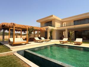 a villa with a swimming pool and a house at Villa Tarrafal in Somone