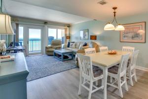 a kitchen and living room with a table and chairs at ‘Emerald Dreams’ Beach & Lakefront West PCB Condo in Panama City Beach
