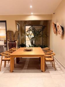 a dining room with a wooden table and chairs at Villa Tarrafal in Somone