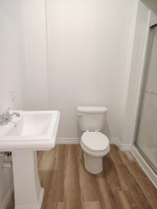 a white bathroom with a toilet and a sink at Sunny Ensuite Room with 2 Queen Beds-2A in Halifax
