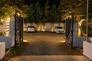 a gate to a driveway at night with cars parked at The Regal IVY Hotel in Nainital +4 photos