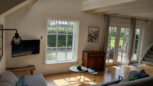a living room with a couch and a table at Ruime Vakantiewoning - Hoeve Niets meer - met eigen privé terras en tuin in Balkbrug