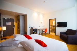 a bedroom with a large white bed with red pillows at Les Jardins du Mess in Verdun +28 photos