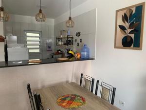 a table and chairs in a kitchen with a counter at Praia do Frances-Riviera do Frances casa 37 in Marechal Deodoro