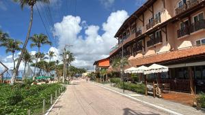 an empty street in front of a building with palm trees at Praia do Frances-Riviera do Frances casa 37 in Marechal Deodoro