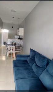 a blue couch in a living room with a table at DUNAS RESIDENCE CASA 12 in Santo Amaro