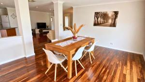 a dining room with a wooden table and white chairs at Wagon Holiday Home in Broadwater +21 photos