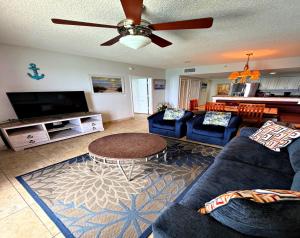 a living room with blue couches and a ceiling fan at Wyndham Ocean Walk 2 BR Resort Condo Direct Oceanfront - Daytona Funland 22260 in Daytona Beach
