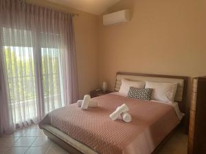 a bedroom with a bed with two towels on it at Eri's House in Chrysoupolis