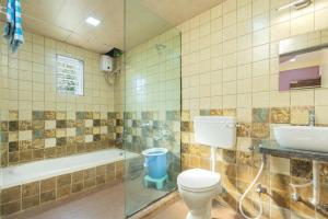 a bathroom with a toilet and a sink and a tub at Jalsa Bungalow in Malavli +8 photos
