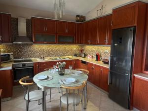 a kitchen with a table and a black refrigerator at Eri's House in Chrysoupolis