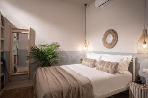 a bedroom with a bed with white sheets and a mirror at Ninemia Shore Retreat in Stalis in Stalís +29 photos