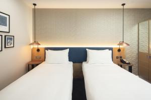 two beds in a room with two lamps at Hilton Garden Inn Bristol City Centre in Bristol