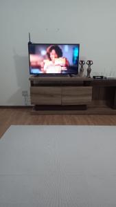 a flat screen tv sitting on a wooden entertainment center at Apartamento em Pelotas Centro in Pelotas