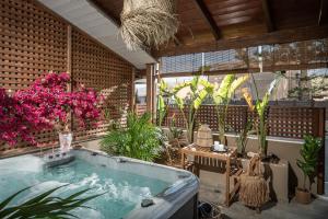 a bath tub in a room with plants at Ninemia Shore Retreat in Stalis in Stalís