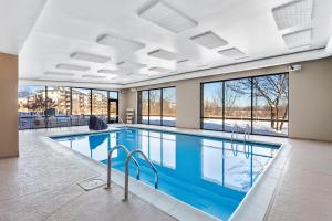 a swimming pool in a building with windows at Hampton Inn & Suites Chicago Deer Park in Deer Park