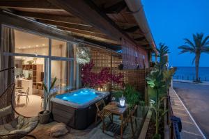 a hot tub on the patio of a house at Ninemia Shore Retreat in Stalis in Stalís