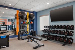 a gym with dumbbells and a flat screen tv at Hampton Inn & Suites West Bend in West Bend