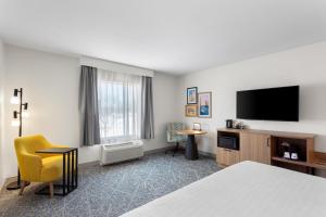 a hotel room with a bed and a flat screen tv at Hampton Inn & Suites Chicago Deer Park in Deer Park