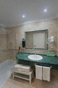 a bathroom with a sink and a mirror and a tub at Hotel Playa del Carmen in Barbate