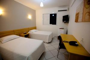a hotel room with two beds and a desk at Hotel Sansaed in Cuiabá +39 photos