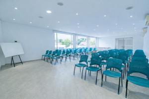a conference room with blue chairs and a white board at Casa Serena Hotel Boutique in Melgar