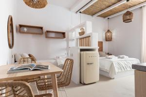 a room with a table and a refrigerator and a bed at EOS Gaeta in Gaeta