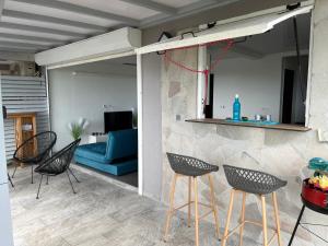 a living room with chairs and a blue couch at Ti kaz belair in Le Diamant