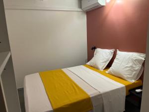 a bedroom with a bed with yellow and white sheets and pillows at Ti kaz belair in Le Diamant