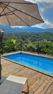 a swimming pool sitting on a wooden deck with an umbrella at Sole d'Oro in San-Nicolao