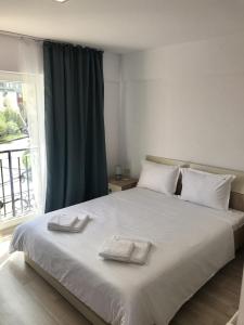 a bedroom with a large bed with two towels on it at Beach House in Mamaia Sat/Năvodari +29 photos