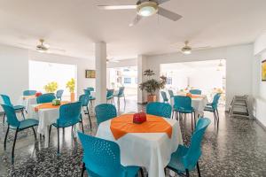 a dining room with white tables and blue chairs at Casa Serena Hotel Boutique in Melgar