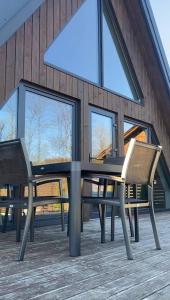 a table and chairs on a deck with windows at Lofty House Mountain Tustan in Urych +40 photos