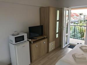 a room with a microwave and a television on a cabinet at Beach House in Mamaia Sat/Năvodari
