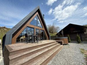 a house with a wooden deck with a table and chairs at Lofty House Mountain Tustan in Urych