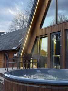 a hot tub in front of a house at Lofty House Mountain Tustan in Urych