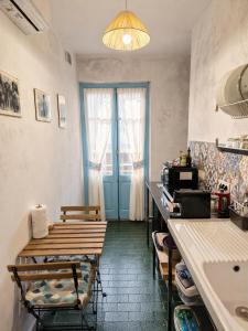 a kitchen with a table and a blue door at Paradice in Baunei in Baunei